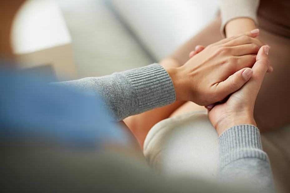 Close-up of two hands holding each other, symbolizing empathy, support, and connection