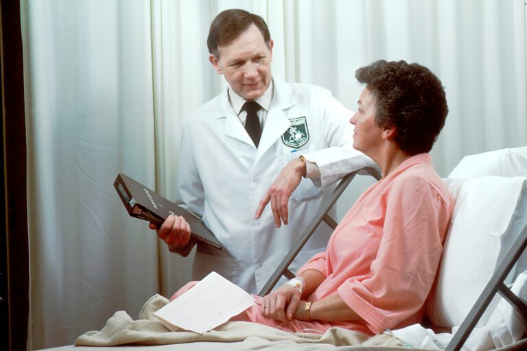 A doctor in a white coat consulting with a patient in a hospital setting, discussing medical reports