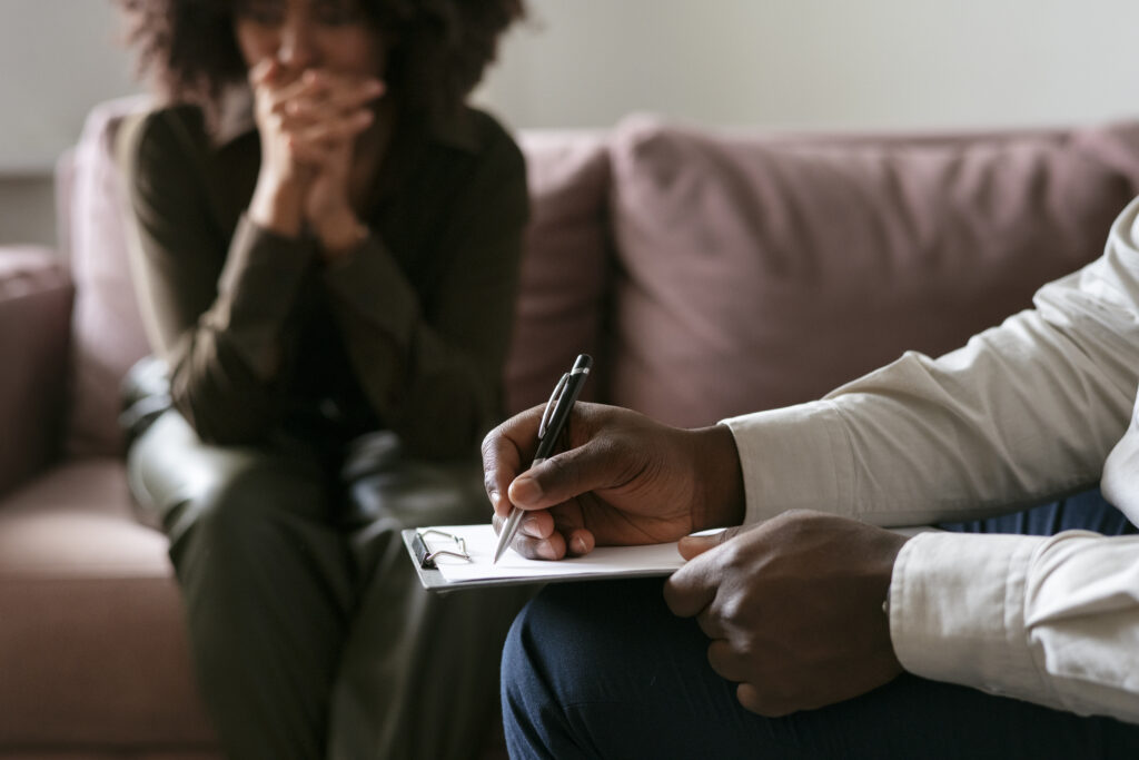 Close-up of a person handing a pen and document to another individual for signing, depicting agreement or consent.