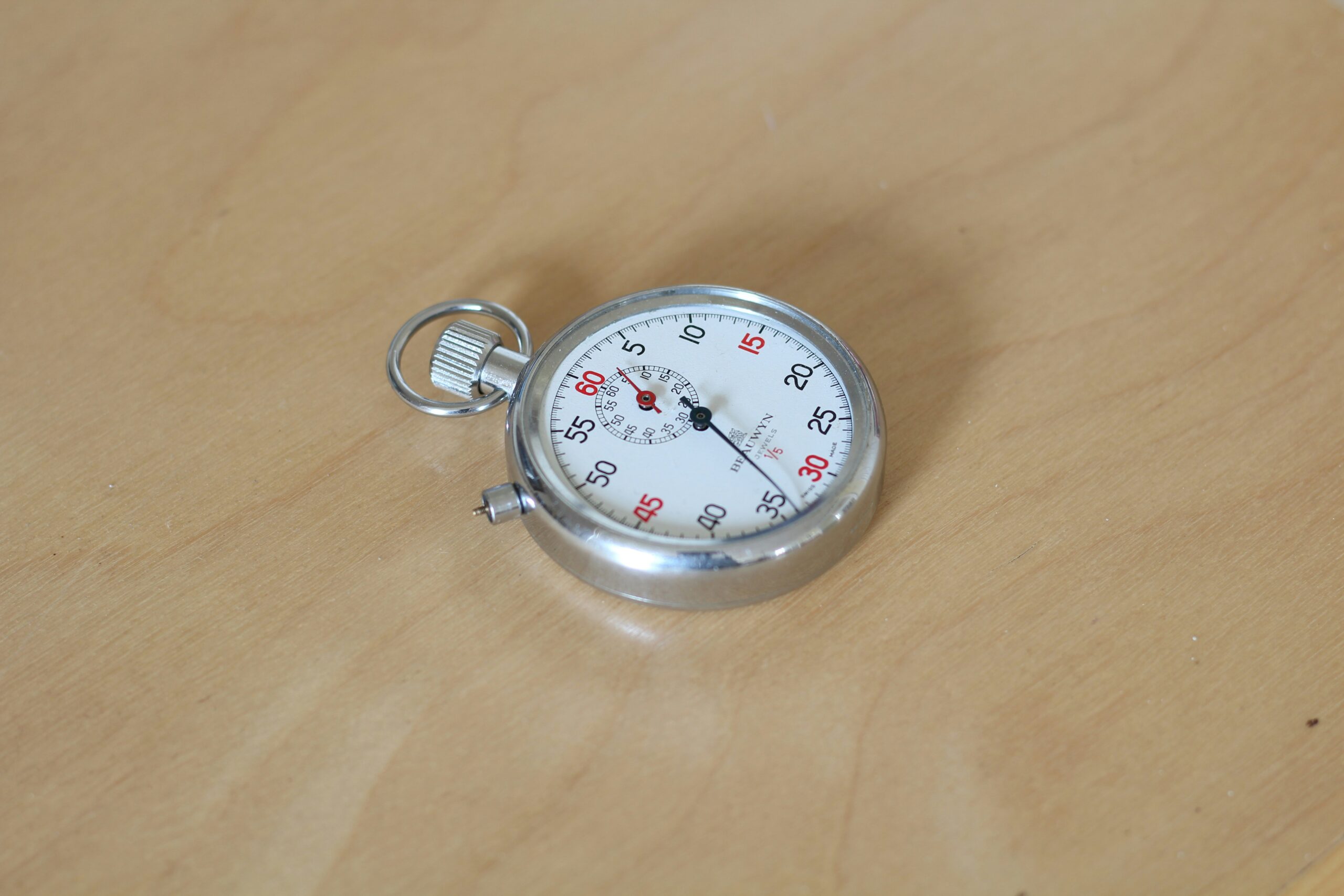 A stopwatch placed on a wooden table, symbolizing time management and precision